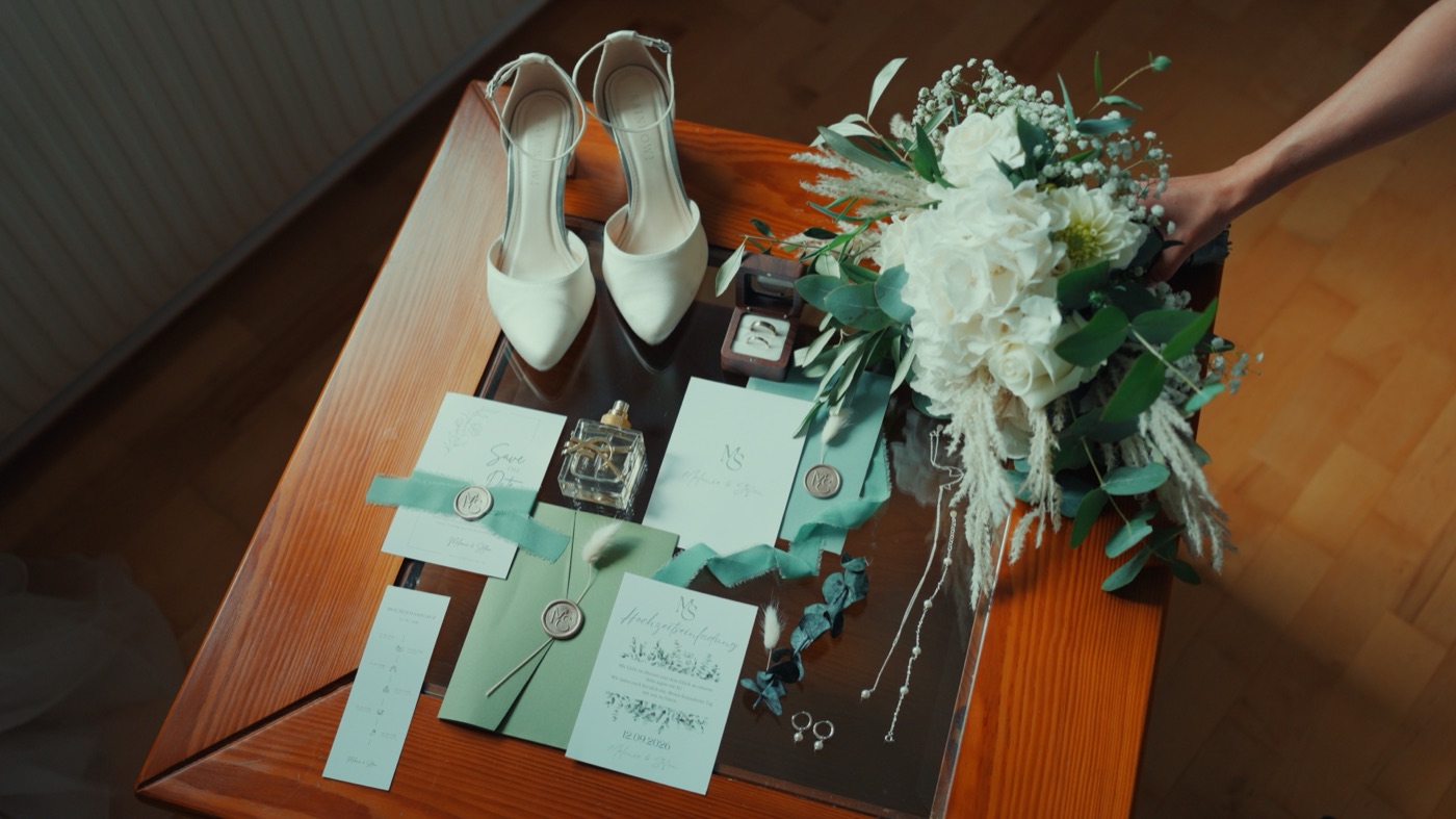 Brautstrauß, Schuhe, Ringe und Einladungen als Detail-Flatlay